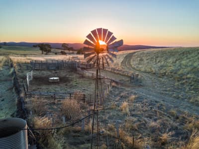 Aerial Image of A WINDMILL AND CATTLE YARDS AT SUNSET AT MOUNT FRANKLIN